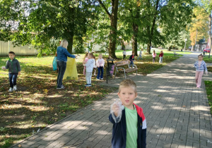 Dzieci w parku sprzątają śmieci i od razu je segregują.