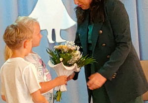 Hania i Bartek wręczają kwiaty pani Elżbiecie Stępień.