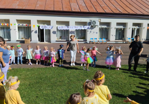 Grupa Motylków tańczy wesoło w kole.