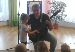 Ada próbuje gry na gitarze elektrycznej.