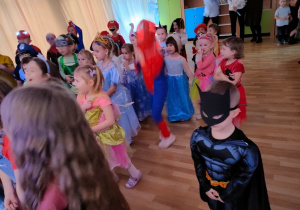 Przedszkolaki zebrane w sali balowej, słuchają instrukcji do tańca , wydawanych przez Pana Wodzireja.