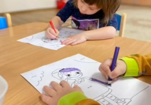 Dziewczynka koloruje sylwetę dziewczynki. Napis: C-Celinka.