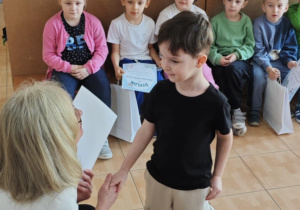 Ignaś z grupy 4-latków odbiera z rąk Pani Dyrektor swoje nagrody za udział w wystawie.
