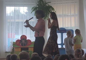 Muzycy prezentują dzieciom gre na flecie.