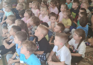 Dzieci w skupieniu słuchają audycji muzycznej.
