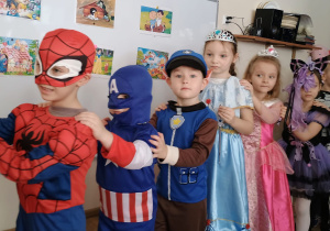 Dzieci w przebraniach tańczą tworząc korowód.