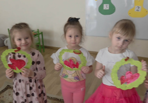 Dziewczynki trzymają w rączkach laurki otrzymane od chłopaków.