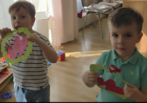 Chłopcy trzymają w rączkach laurki dla dziewczynek.