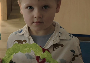 Antoś trzyma w rączce laurkę dla koleżanki.