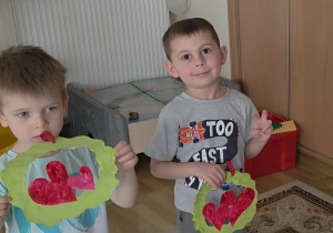 Chłopcy trzymają w rączkach laurki dla dziewczynek.