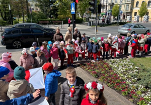 Korowód przedszkolaków pod pomnikiem.