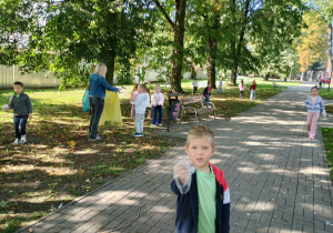 Dzieci w parku sprzątają śmieci i od razu je segregują.