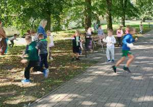 Dzieci w parku sprzątają śmieci i od razu je segregują.