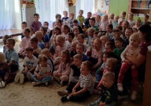 Przedszkolaki i nauczyciele w sali przedszkolnej w oczekiwaniu na pokaz iluzji.