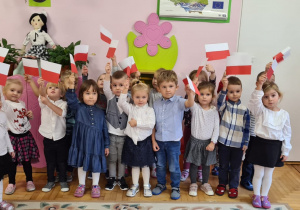 Dzieci z grupy 3-latków trzymają chorągiewki-flagi Polski.