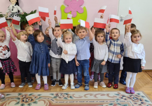 Dzieci z grupy 3-latków trzymają chorągiewki-flagi Polski.