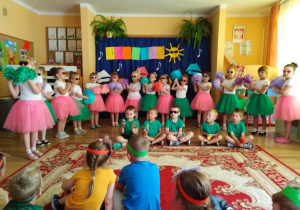 4-,5-latki w kolorowych strojach i okularach przeciwsłonecznych witają lato piosenką.