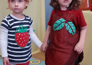 Dziewczynka z grupy 3-latków w stroju truskawki i chłopiec w stroju buraczka.