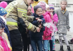 Przedszkolaki miały możliwość wypróbowania pompy strażackiej.