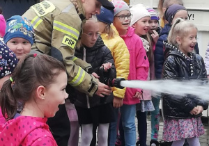 Przedszkolaki miały możliwość wypróbowania pompy strażackiej.