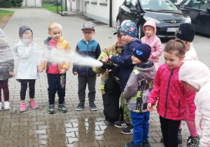 Przedszkolaki miały możliwość wypróbowania pompy strażackiej.