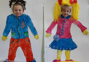 Namalowana postać chłopca i dziewczynki, w miejscu na twarz buźki dzieci z grupy 5-latków.