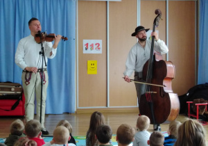 Górale ze Szczyrku grają na skrzypcach i wiolonczeli dla przedszkolaków.