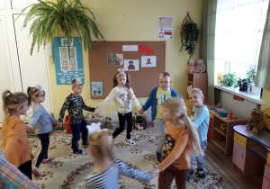 5-latki tańczą w kole podczas Dnia Pluszowego Misia.