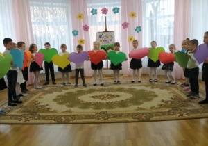Dzieci 5-,6-letnie trzymają duże kolorowe serca podczas występu dla Babć i Dziadków.
