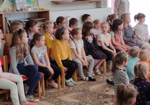 Dzieci w skupieniu oglądają występy swoich kolegów, koleżanek i nauczycieli.