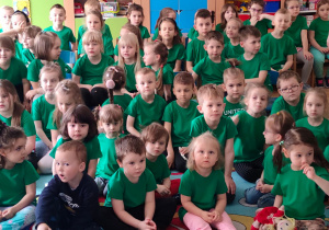 Wszystkie przedszkolaki w zielonych podkoszulkach oglądają film edukacyjny oraz teatrzyk o Smokach.