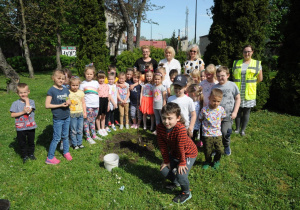 Dzieci z grupy Promyczków podczas sadzenia drzewka jabłoni w ogrodzie przedszkolnym.