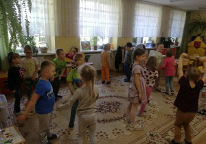 Przedszkolaki podczas tanecznej zabawy w przedszkolnej sali.