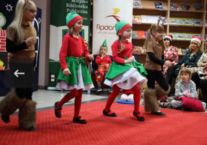 Dziewczynki w stojach elfów i reniferów podczas tańca.