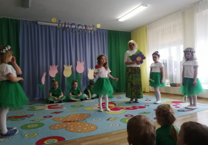Dziewczynki w strojach wiosennych wróżek i pani Grażynka podczas przedstawienia.