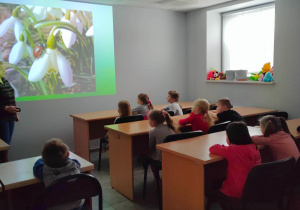 5,6 latki oglądają film edukacyjny o budzącej się wiosną do życia przyrodzie.