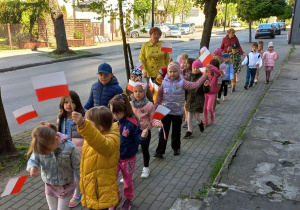 Dzieci trzymają flagi Polski samodzielnie wykonane i maszerują ulicami naszego miasta.