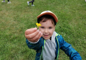 Chłopiec trzyma żółty kwiatek.