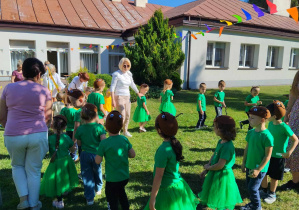 Grupa zielonych Żuczków tańczy w kole.