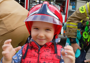 Chłopiec w kasku strażackim.