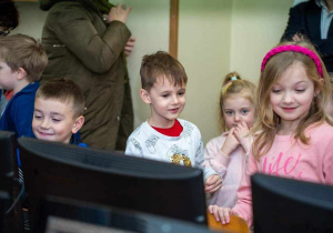 Dorotka, Zuzia i Mikołaj za monitorem komutera, wyraźnie zainteresowani informacjami przekazywanymi przez starszych kolegów.