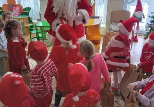 Mikołaj i dzieci z grupy Promyczki obdarowane prezentami.