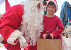 Ala pozuje do zdjęcia z Mikołajem i ze swoim prezentem.