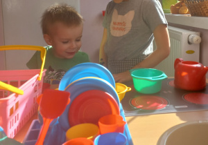 Dzieci bawią się w kąciku kuchennym.