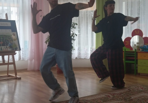 Para tancerzy w luźnych strojach tańczy hip-hop.