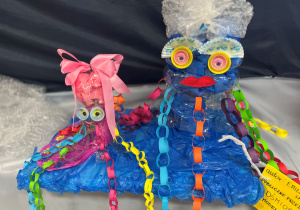 Dwie meduzy z materiałów recyklingowych w kolorze niebieskim, macki wykonane z kolorowych, papierowych łańcuchów.