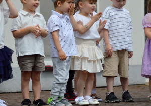 Maluszki w opaskach ze słoneczkiem podczas występu dla rodziców.