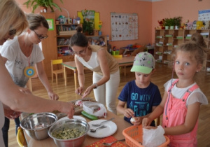 Rodzice pomagaja w przygotowywaniu sałatek