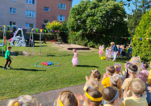 Przedszkolaki podczas konkurencji przenoszenia piłeczek w ustalone miejsce.