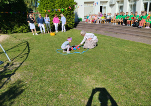 Pani dyrektor i przedszkolak podczas konkurencji przenoszenia piłeczek.